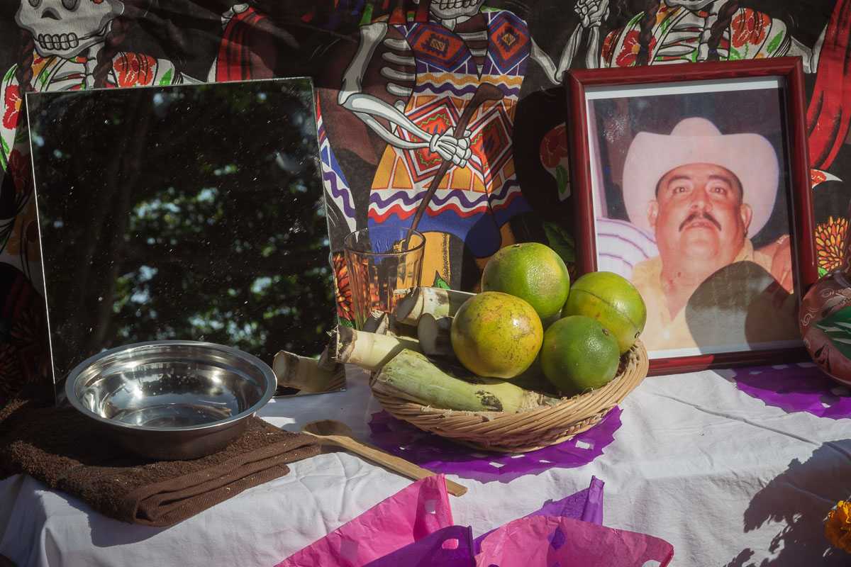 A basket of fruit and sugarcane is among other items left at this altar which include a mirror, a bowl of water and a towel, and a portrait of the deceased.