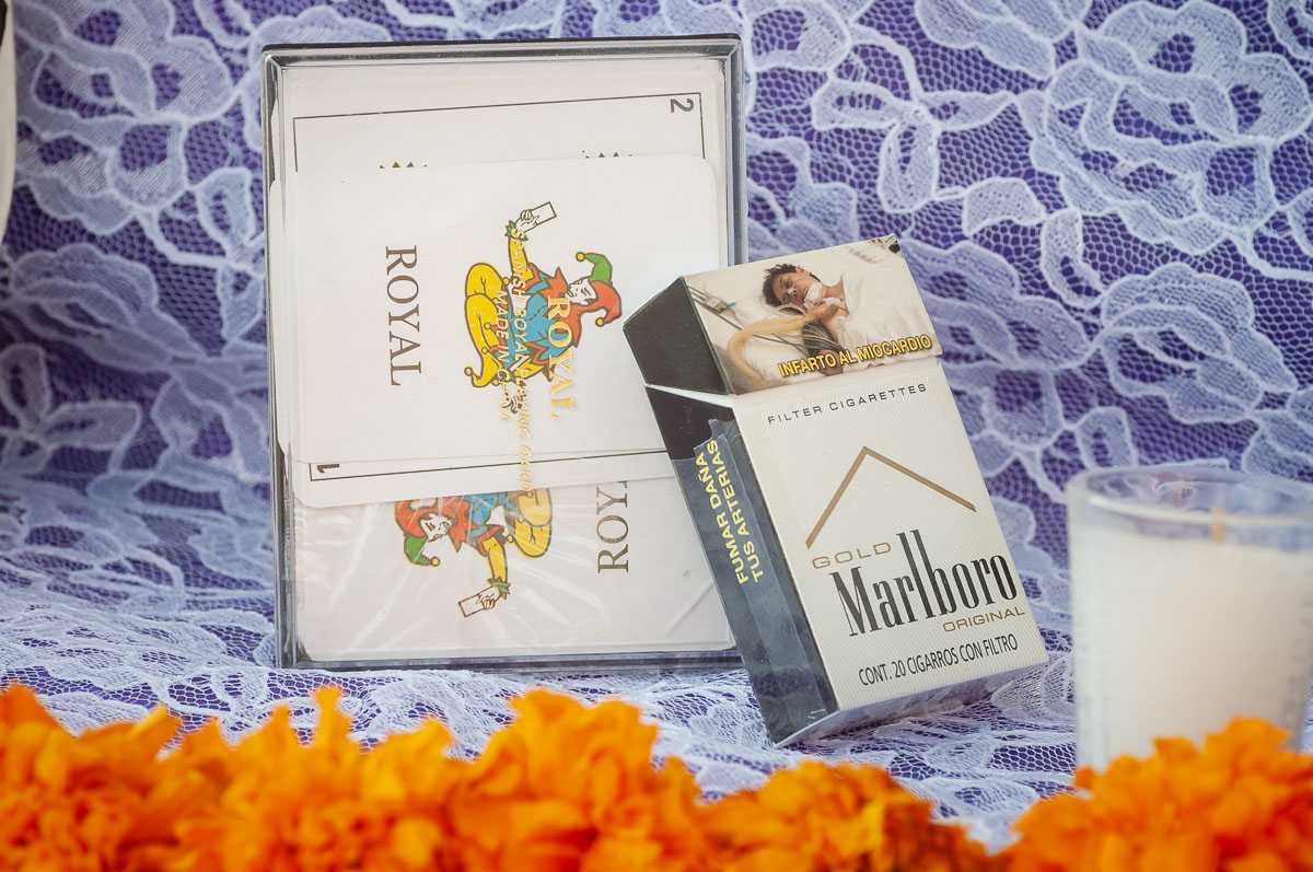 A deck of cards and a pack of cigarettes await the dead.