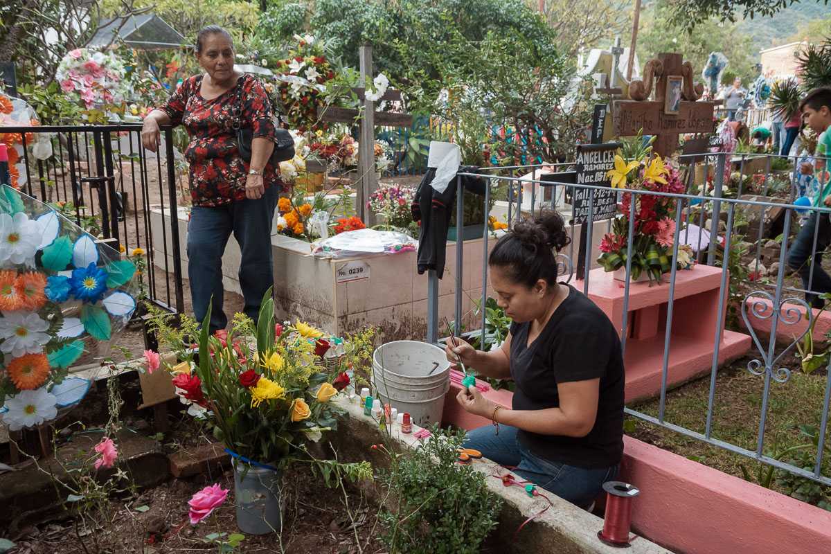 Mari Huizar paints her family's plot in the cemetery on the Day of the Innocents 2018. Her young disabled daughter died in the previous year.