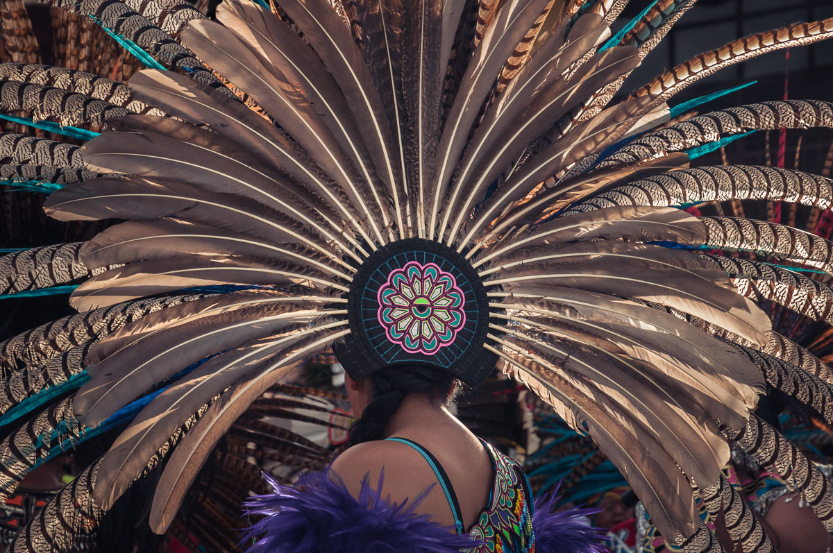 An Aztec dancer wears a large copili headdress made from peacock and turkey feathers during the Fiesta of the Virgin of the Rosary. The Virgin of the Rosary is the town's patroness and has the month of October devoted to her with fireworks, more firework, even more fireworks, and a final procession through bearing an image of the virgin through the town on October 31.