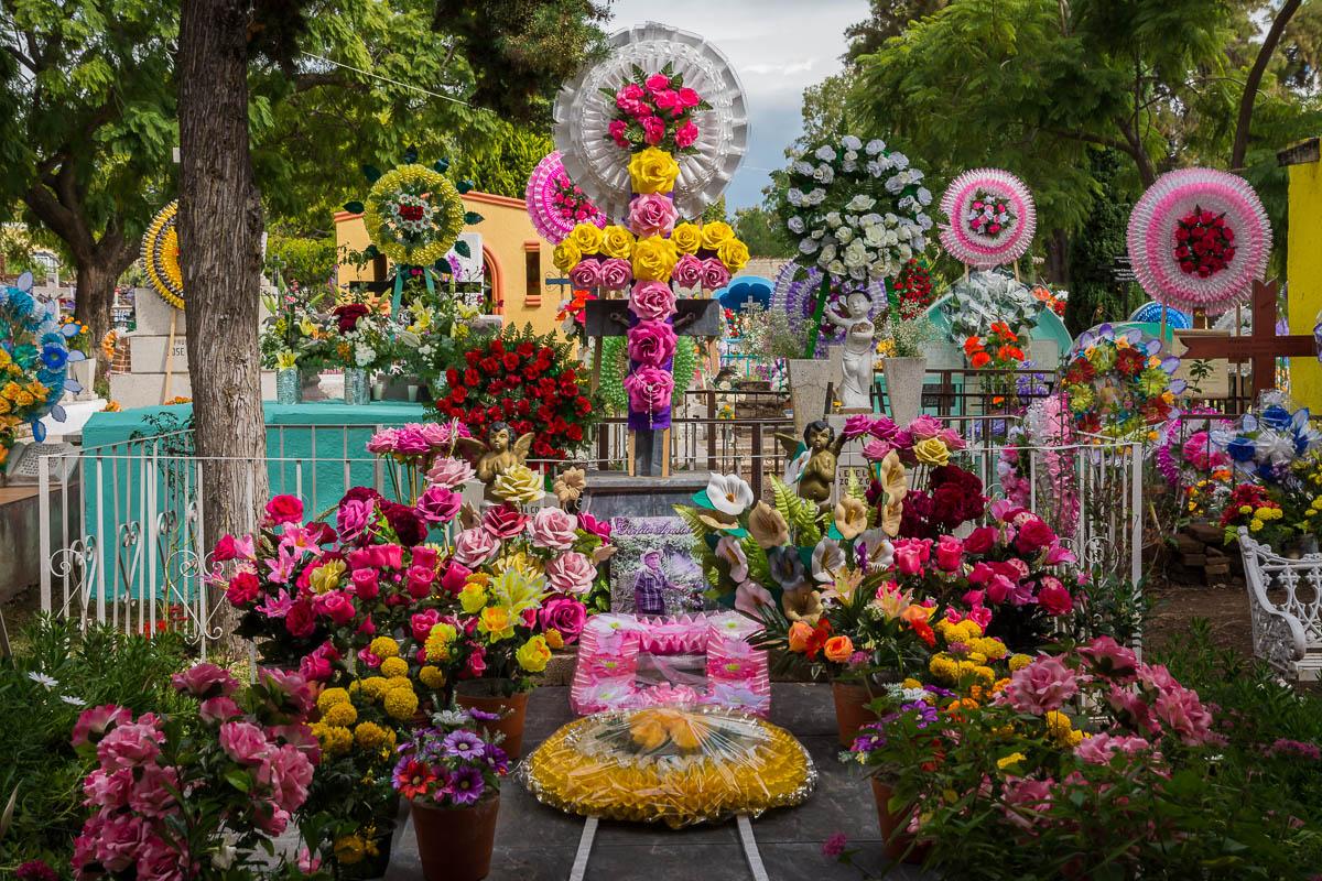 Flower arrangements and coronas line a tomb in the graveyard in San Antonio Tlayacapan.,