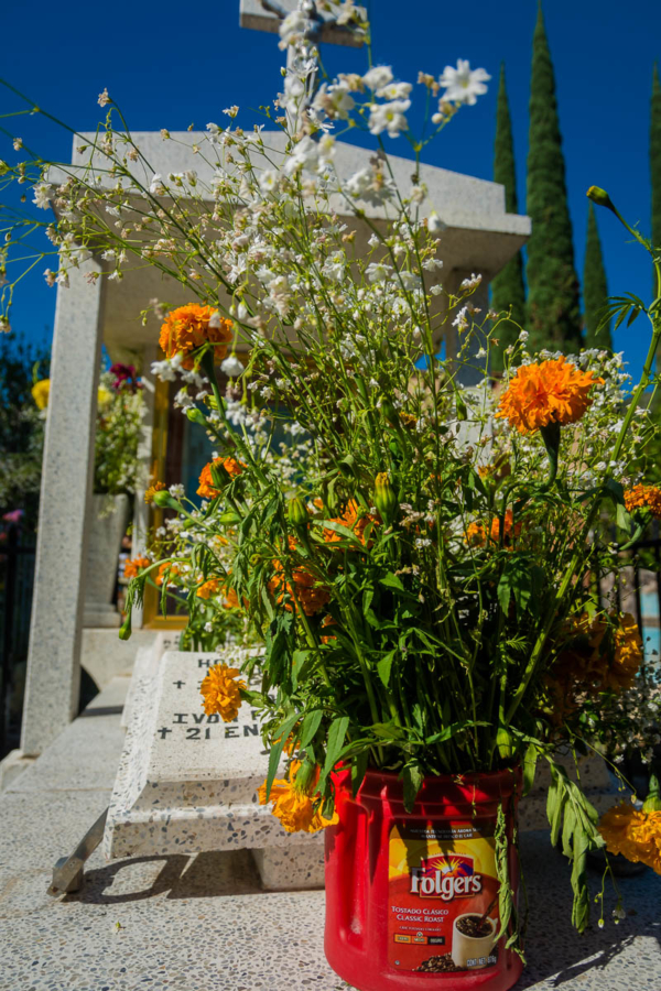 A Folger's coffee can serves as a vase for flowers on the Day of the Dead in Ajijic, Mexico.
