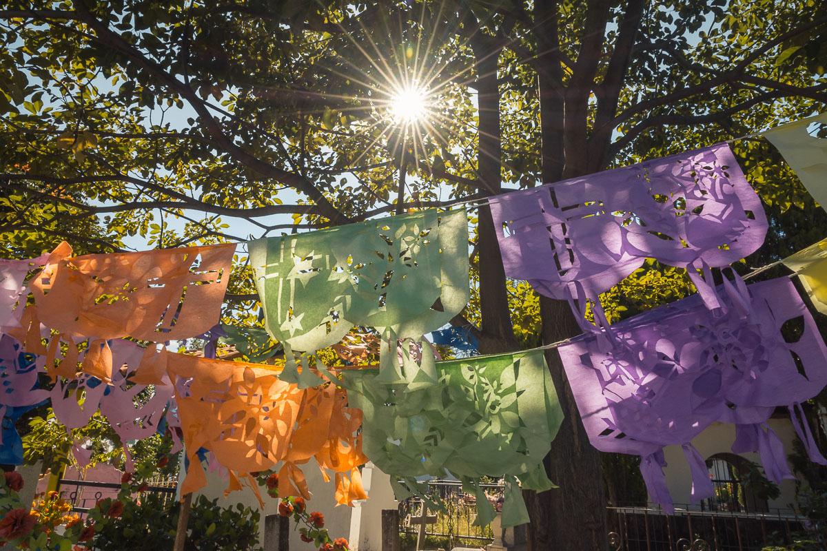 Hand-cut papel picado hangs above a grave in the Ajijic cemetery on the Day of the Dead.