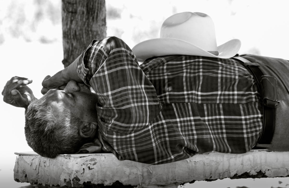 A man takes a siesta on a bench in a cemetery in Sinaloa, Mexico.