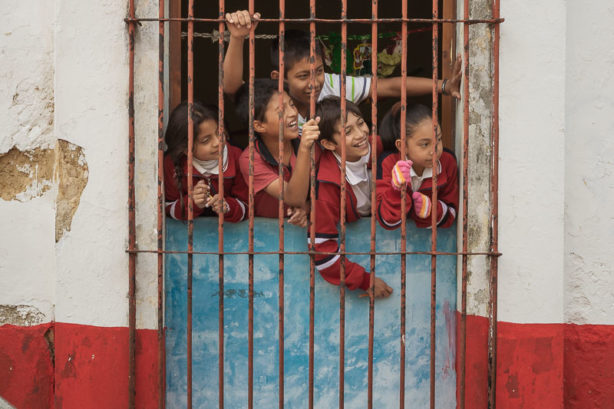 Schoolkids wait for the "Parade of the Fatties" (la Fiesta de los Panzones) in San Cristobal de las Casas, Chiapas, Mexico