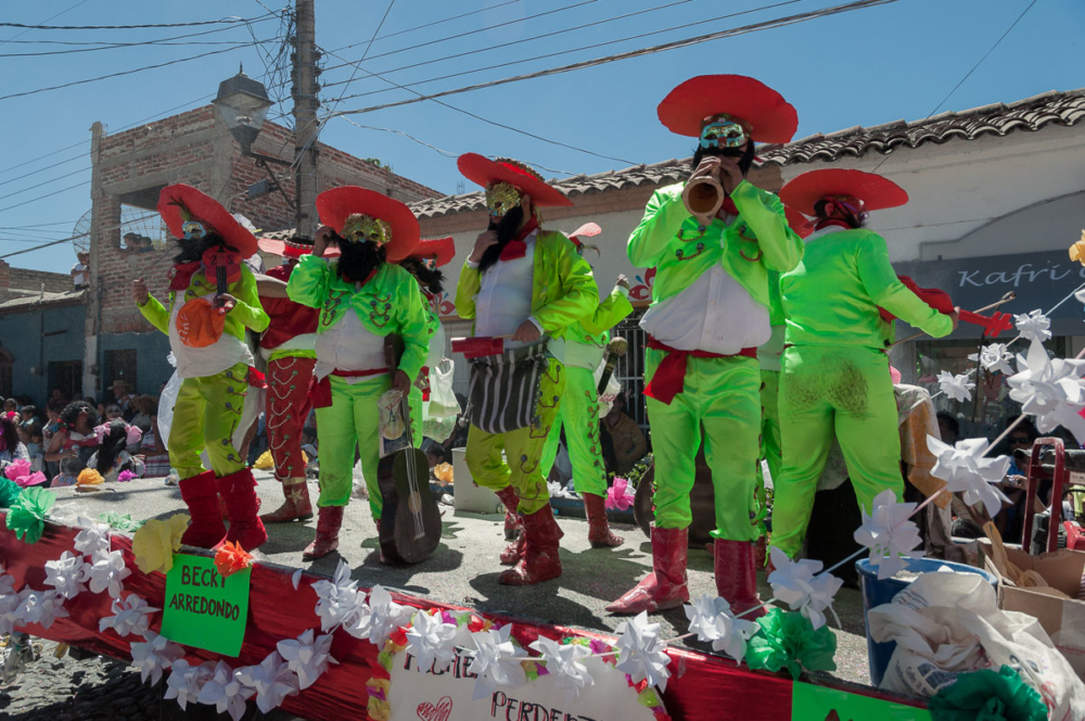 A colorful float with people dressed as banda musicians during the Carnaval-day parade.