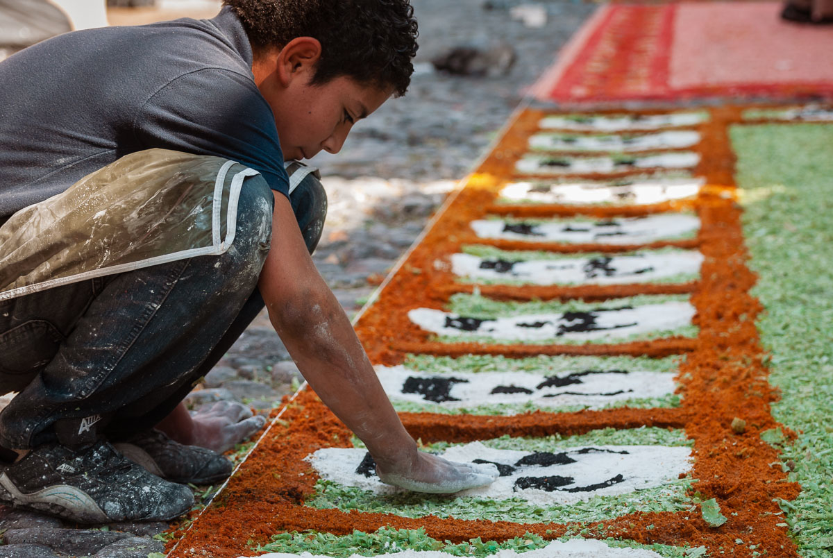 A boy makes a line of skulls on a tapete on the Day of the Dead in Ajijic.